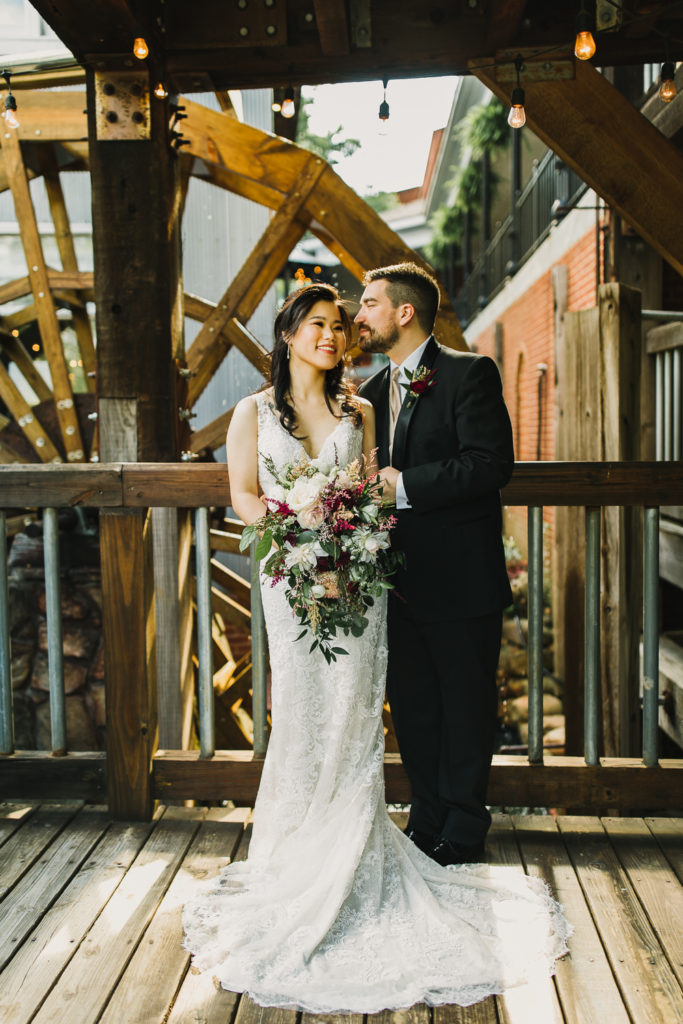 Wedding couple embracing each other at the Cotton Gin at Mill Creek in Georgia. Photo by Meli and Chris Wedding Photography.