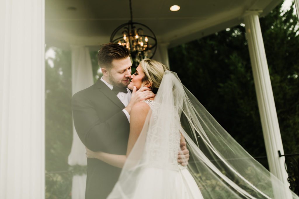 Groom kissing a bride in a Gazebo | Photo by Meli and Chris Atlanta Based destination Wedding Photography. 
