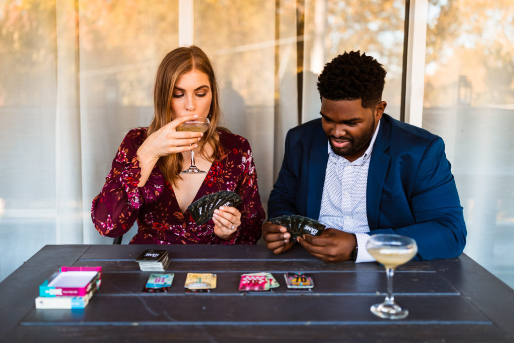 Couple playing cards "The Game" by Pandasaurus Games at Whiskey Bird in Midtown Atlanta Georgia | Photo by Meli and Chris Wedding Photography