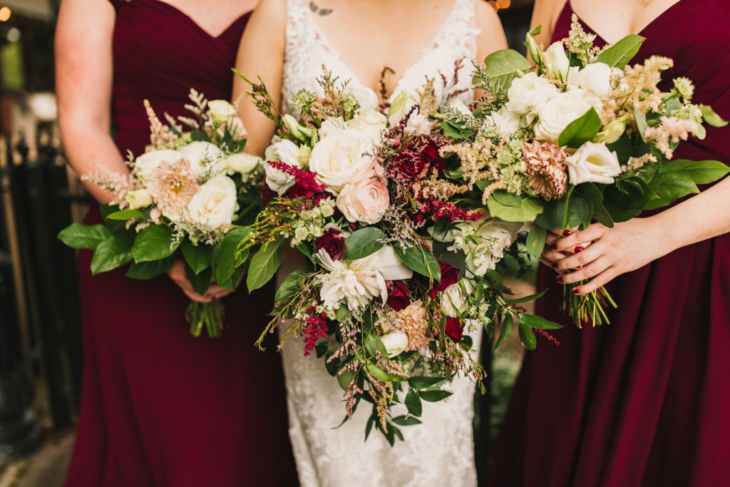 Close up of bride and bridesmaids holding bouquets at the Cotton Gin at Mill Creek. Photo by Meli and Chris Wedding Photography
