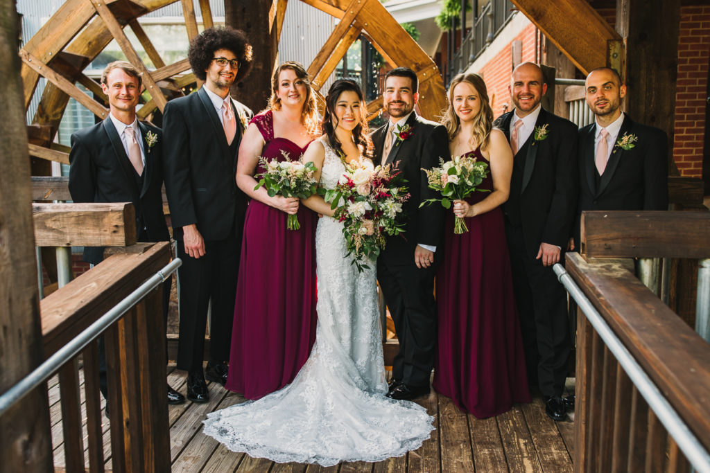 Bridal party in front of water wheel at the Cotton Gin at Mill Creek. Photo by Meli and Chris Wedding Photography atlweddingphotos.com