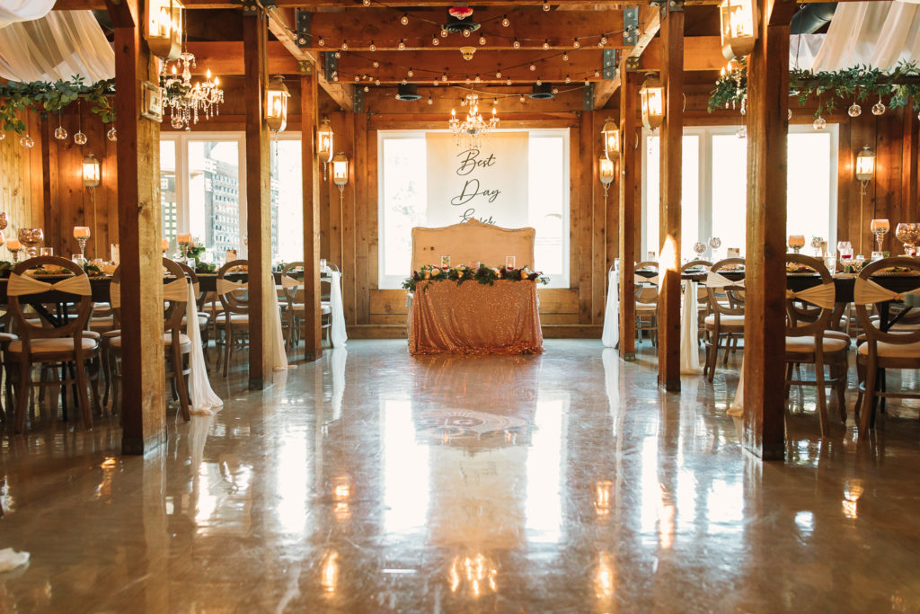 Wedding reception area with shiny floor and wooden walls inside the Cotton Gin at Mill Creek.. Photo by Meli and Chris Wedding Photography atlweddingphotos.com
