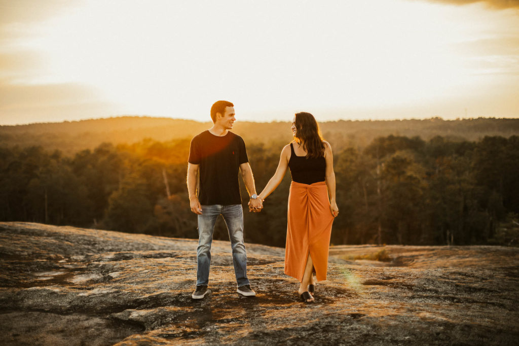 Couple holding hands during sunset at Arabia Mountain National Heritage Area. Photo by Meli and Chris Destination Wedding Photographers | Based in Atlanta Georgia
